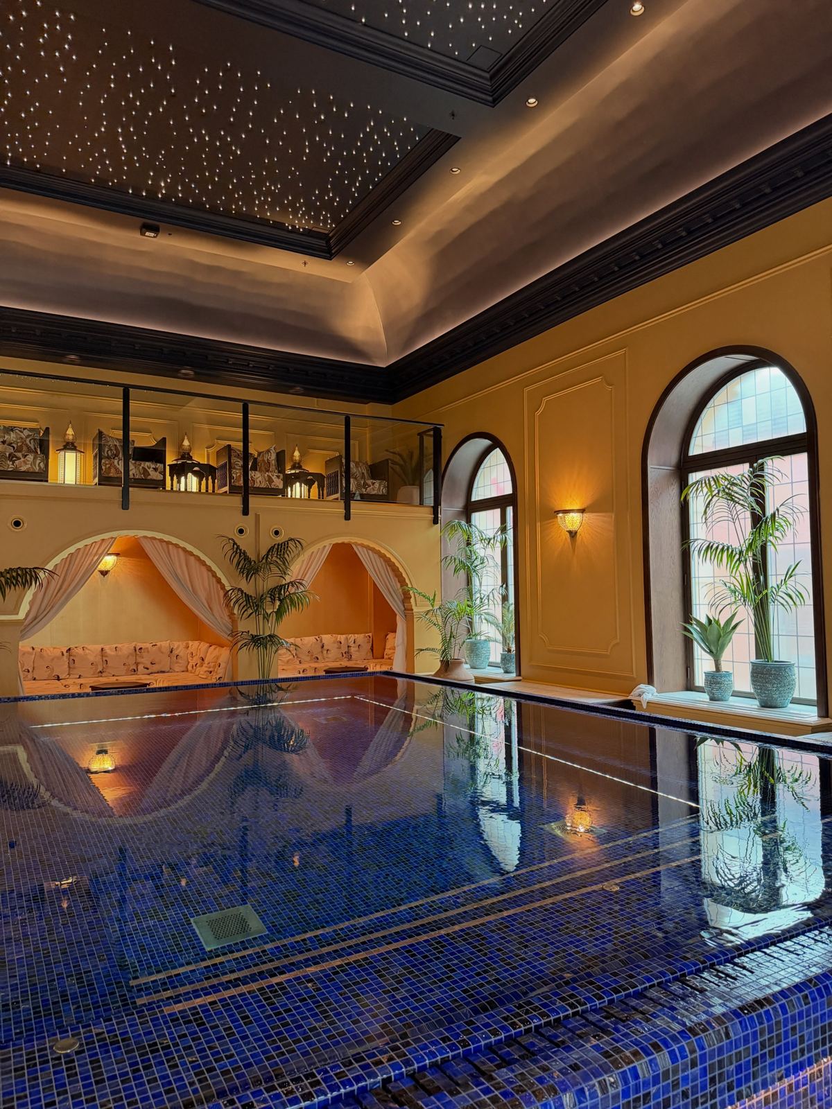 A tiled indoor pool under a starlit ceiling