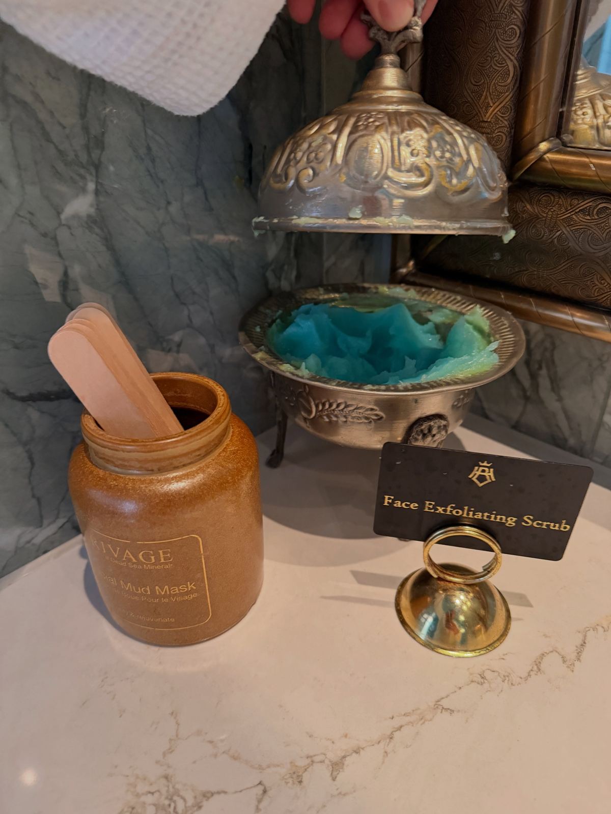 A brass bowl and wooden jar laid out for a spa ritual